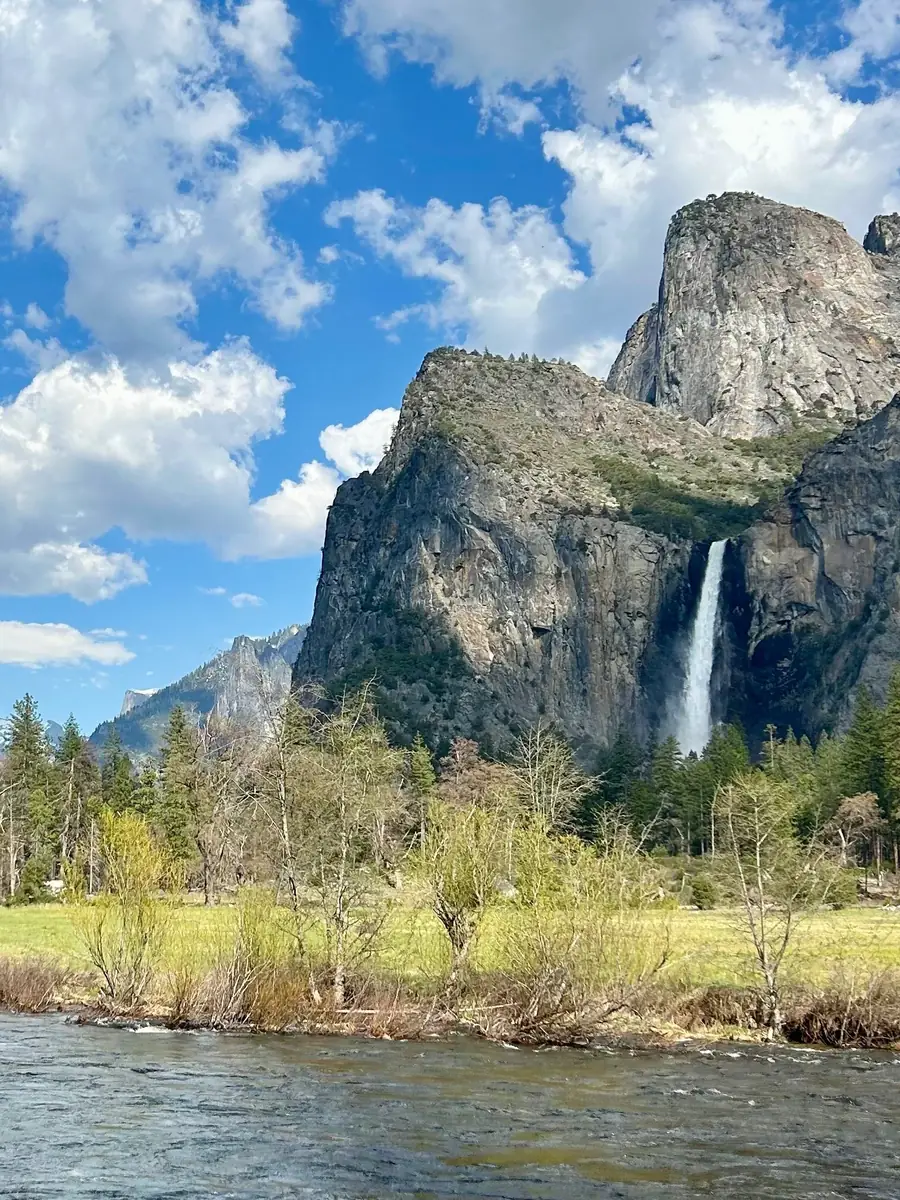 Bridalveil Fall sur une falaise de granite au-dessus de la Merced River et d'une prairie verdoyante